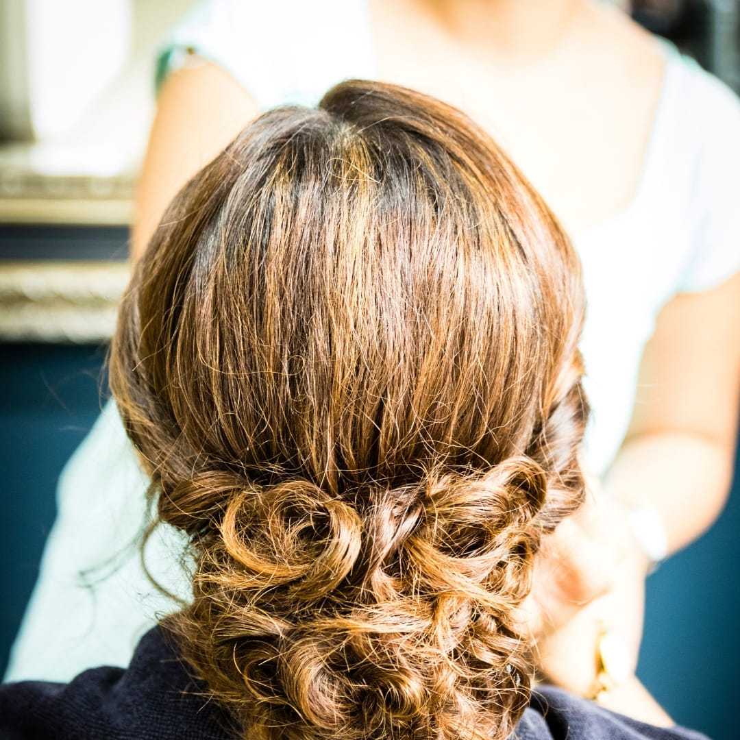 Elegant updo hairstyle on brunette hair with soft curls.